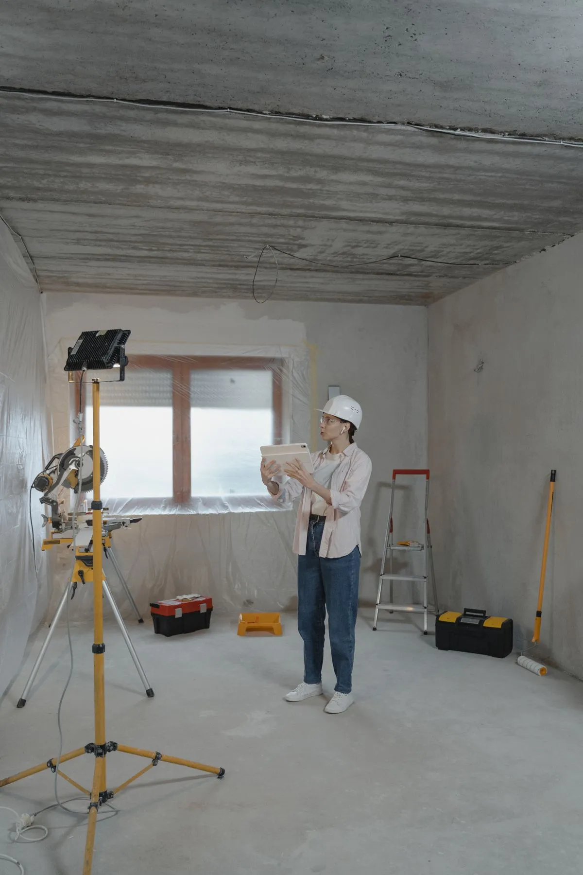 Profissional com capacete consultando o app num tablet no local de trabalho