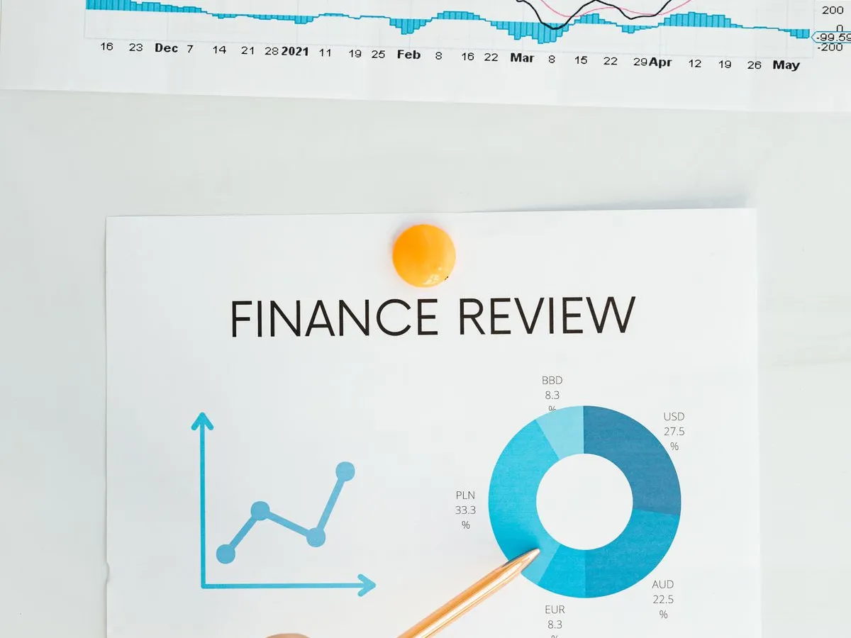 Profissional analisando gráficos e relatórios financeiros, apontando com um lápis para os números