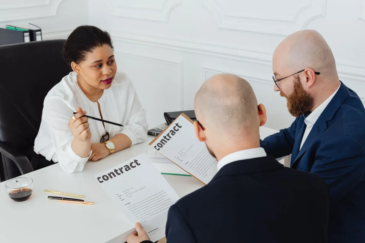 Profissionais revisando um contrato e proposta sobre a mesa no escritório