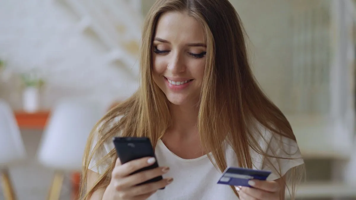 Pessoa sorrindo aprovando uma proposta pelo celular