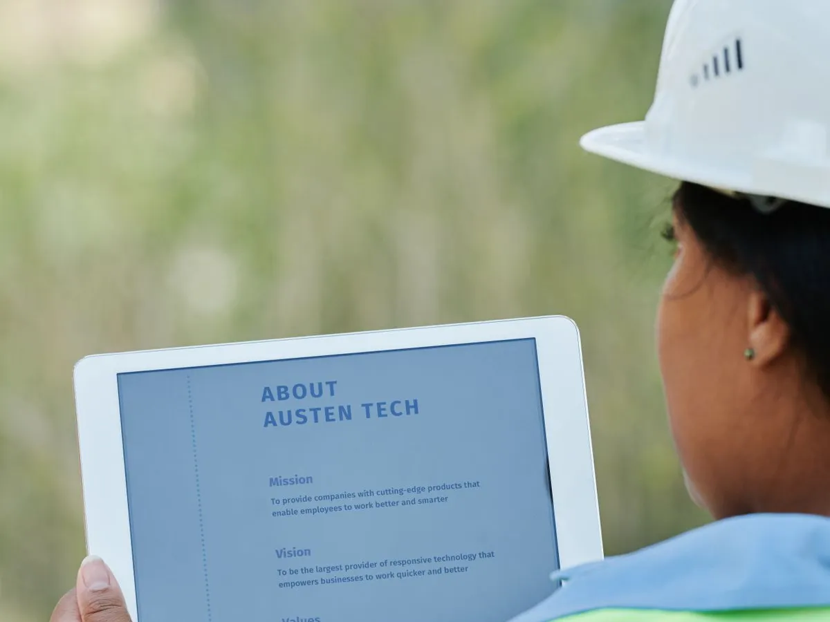 Trabalhador de obra consulta a planta do projeto em um tablet no canteiro